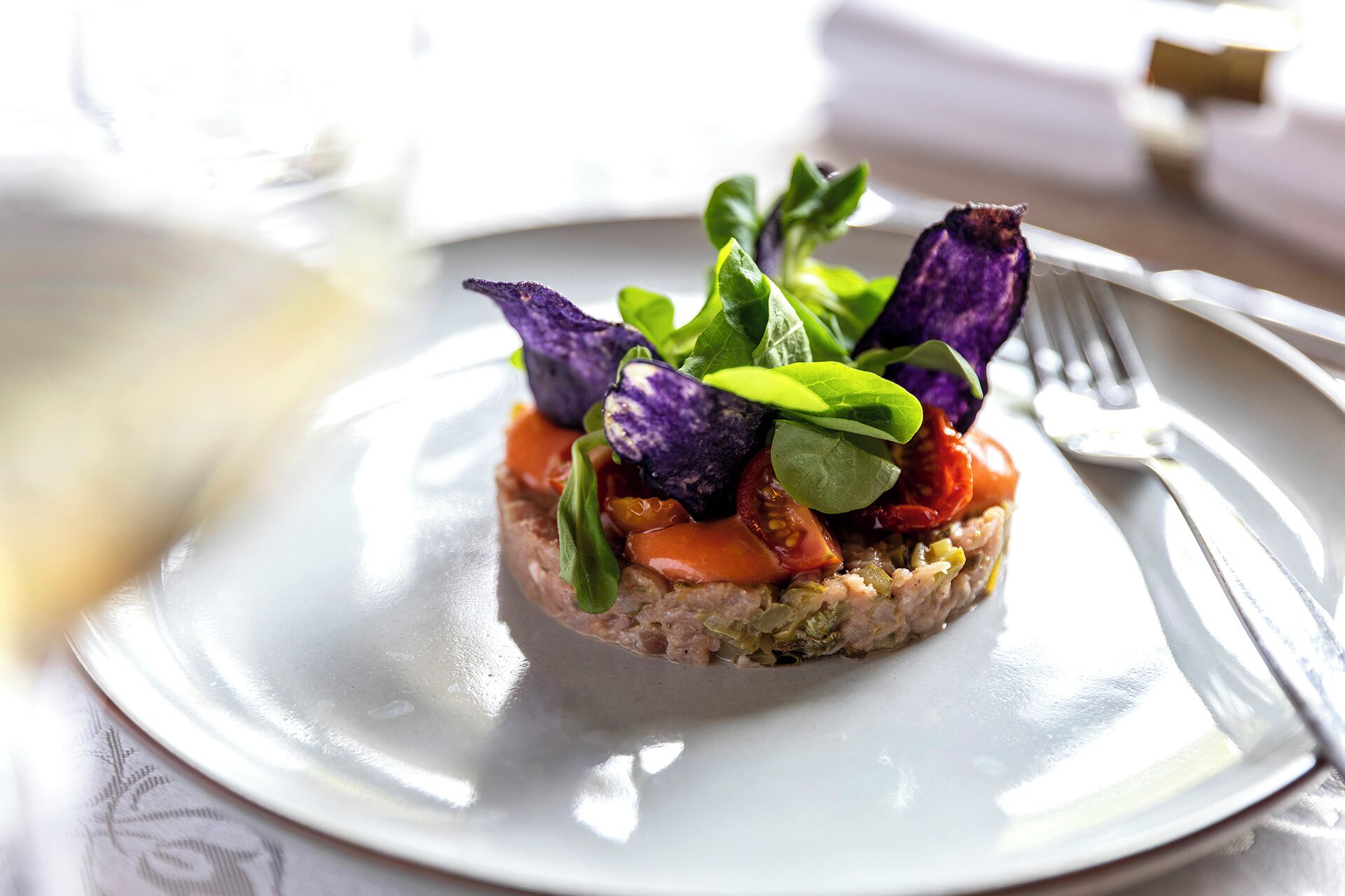 A plated dish with various vegetables and greens.