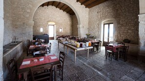 A stone-walled dining area with tables and chairs, featuring arched ceilings and a rustic stone floor. - La Dimora di Spartivento, BW Signature Collection (Ragusa)