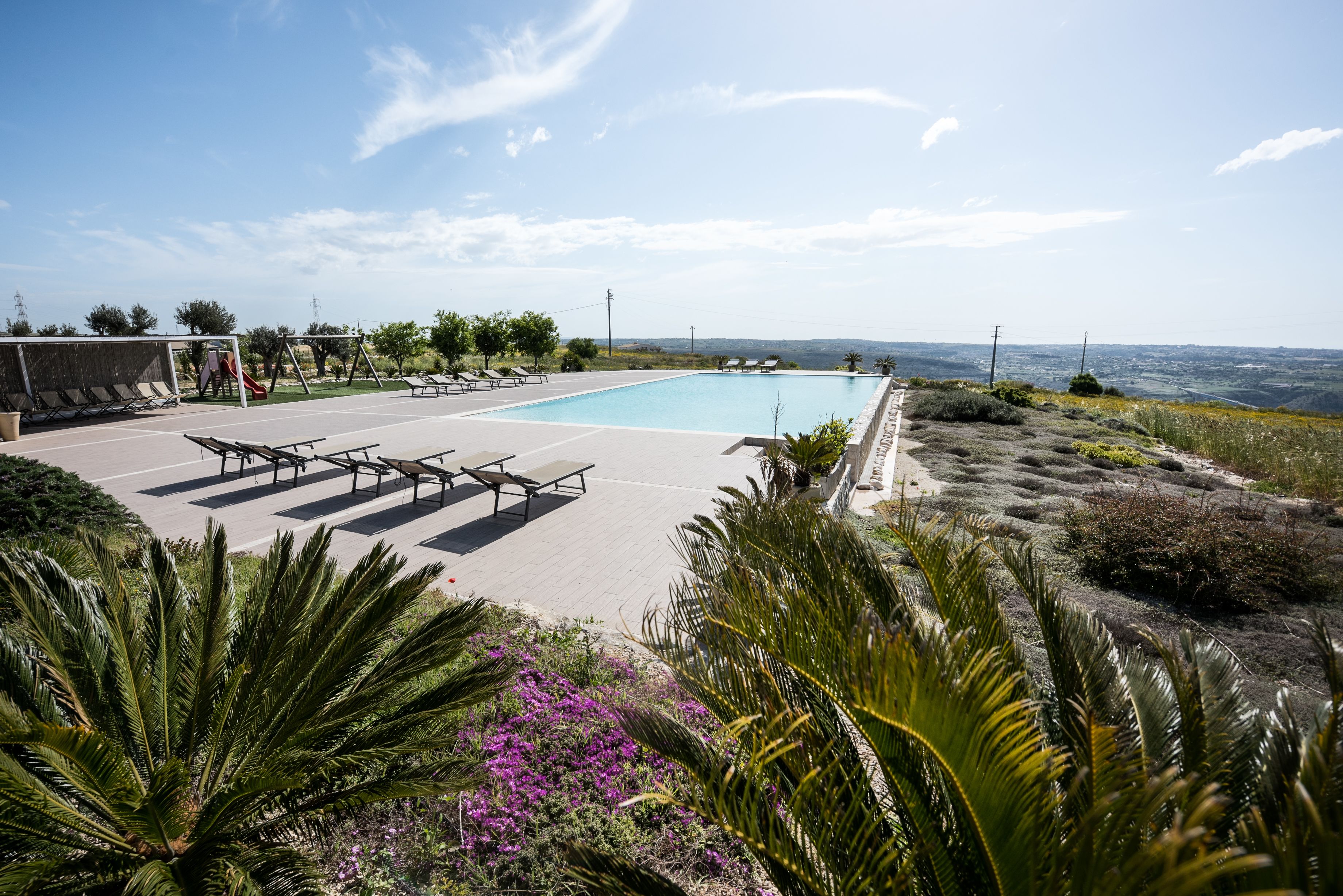 Area piscina con lettini e vista sull'oceano.