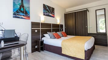 Una habitación de hotel con una cama, un escritorio y un armario.