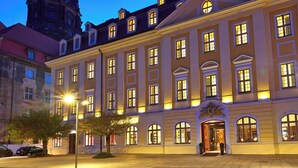Un bâtiment historique doté d’une tour horlogée, de grandes fenêtres et d’une entrée bien éclairée.