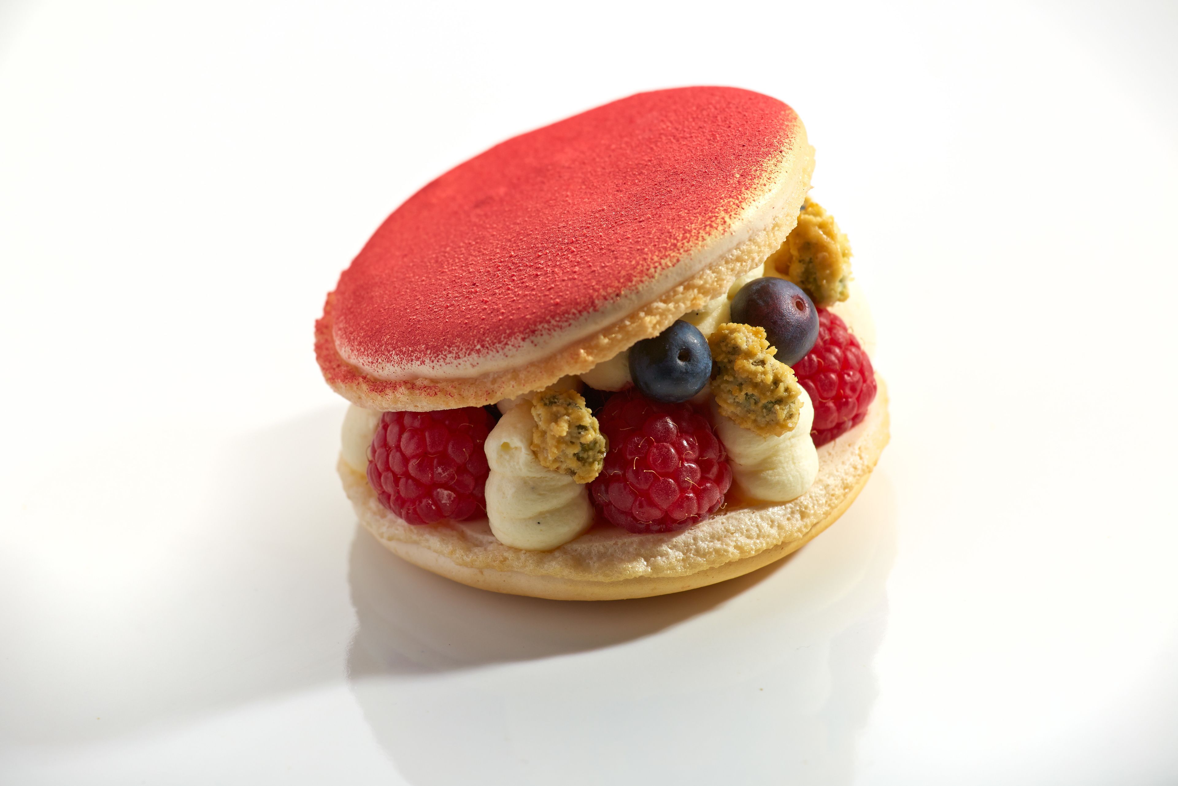 A dessert with a red topping and various berries.