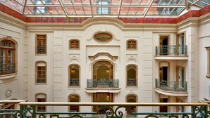 Un atrium à plusieurs niveaux, doté de balcons richement décorés et d’un plafond en verre.