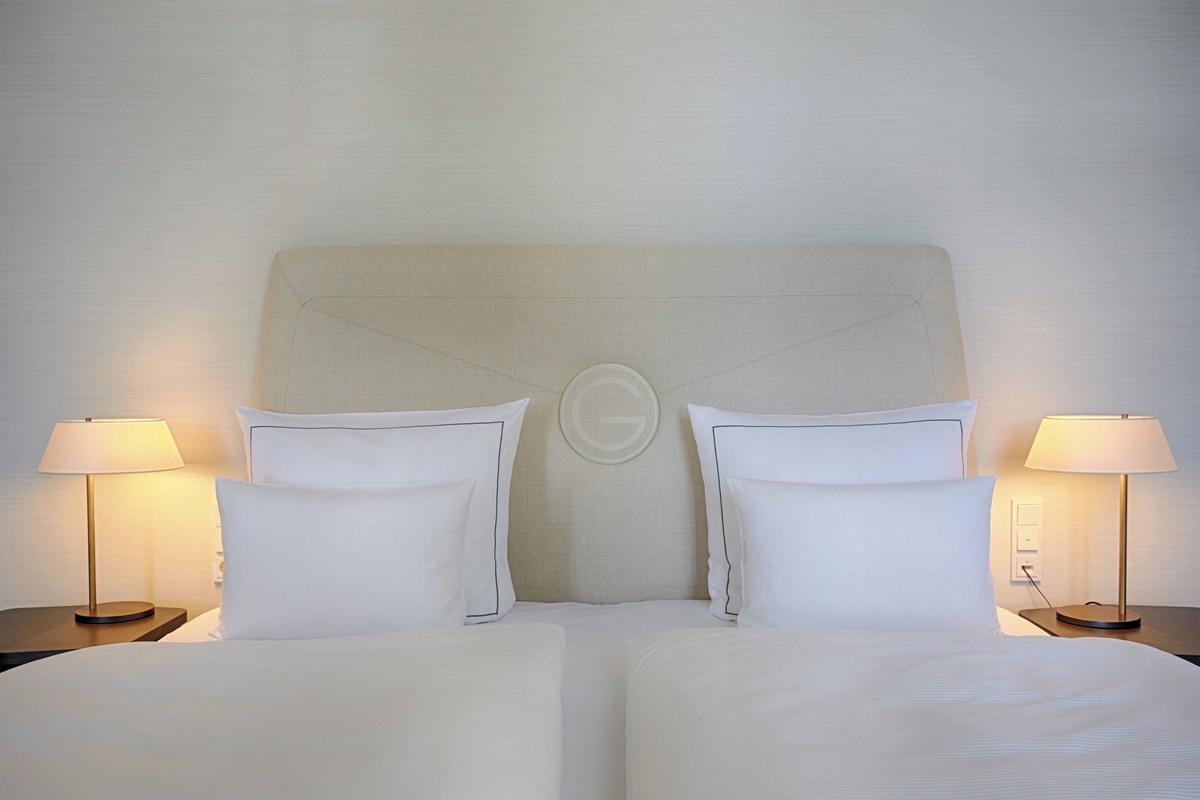 Une chambre d’hôtel avec un grand lit, deux tables de chevet et des lampes.