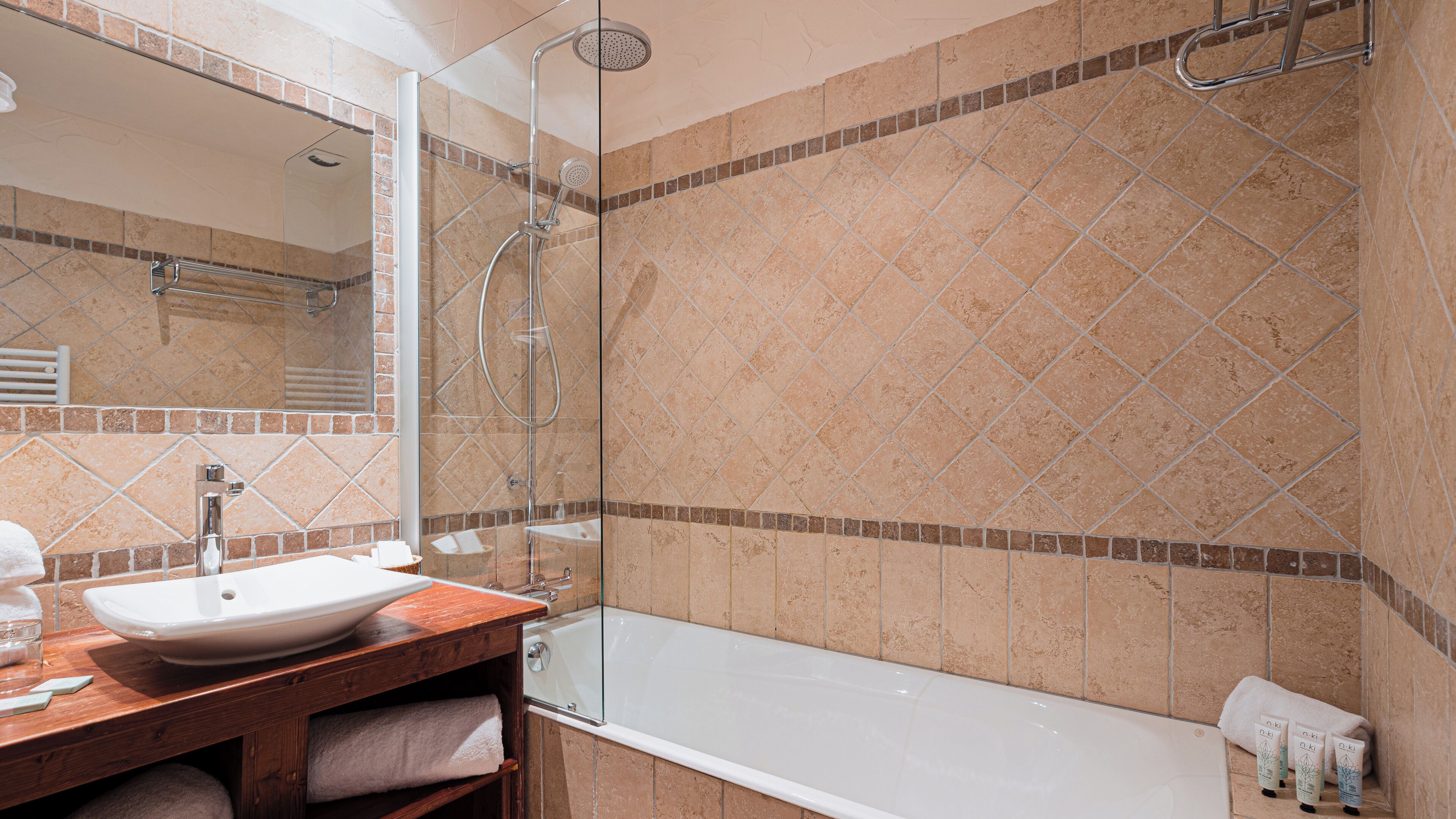 A bathroom with a glass-enclosed shower, a white sink, and a bathtub.