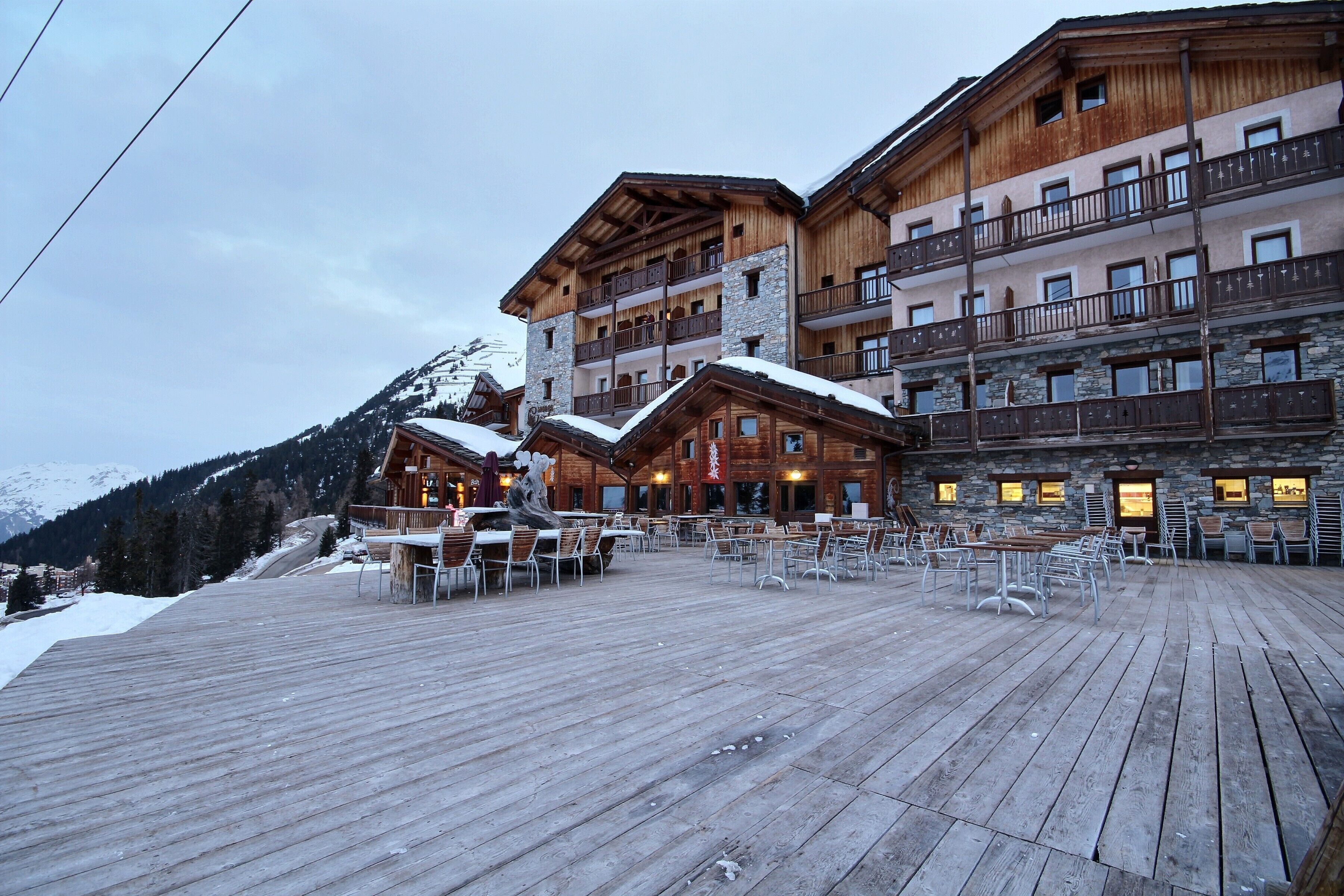 Ein mehrstöckiges Holzhaus mit Balkonen und einer Holzterrasse.