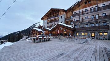 Ein mehrstöckiges Holzhaus mit Balkonen und einer Holzterrasse.