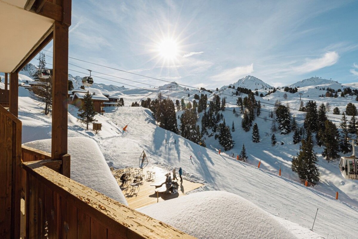 A ski resort with a wooden building, a chairlift, and a snowy landscape.