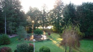 A garden with a pond, surrounded by trees and shrubs. - Hotel Le Tronçais (Saint-Bonnet-Troncais)