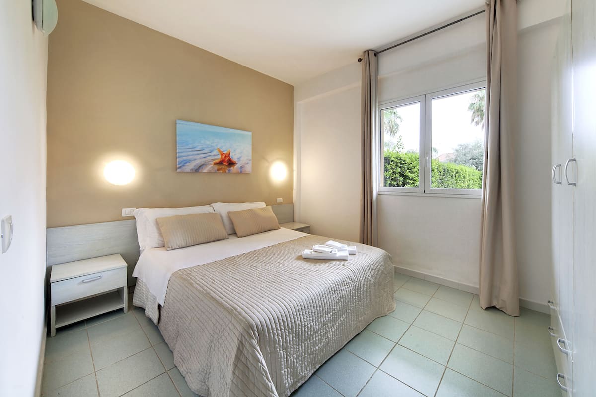 Ein Schlafzimmer mit einem Bett, einem Nachttisch und einem Bild an der Wand.