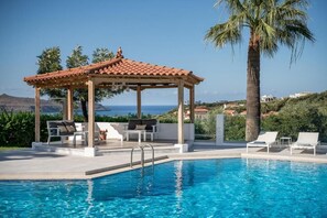Outdoor pool, a waterfall pool, open 8 AM to 9:30 PM, pool umbrellas