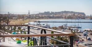 A balcony with a view of a marina and a distant cityscape. - Aqua Marine (Kissamos)