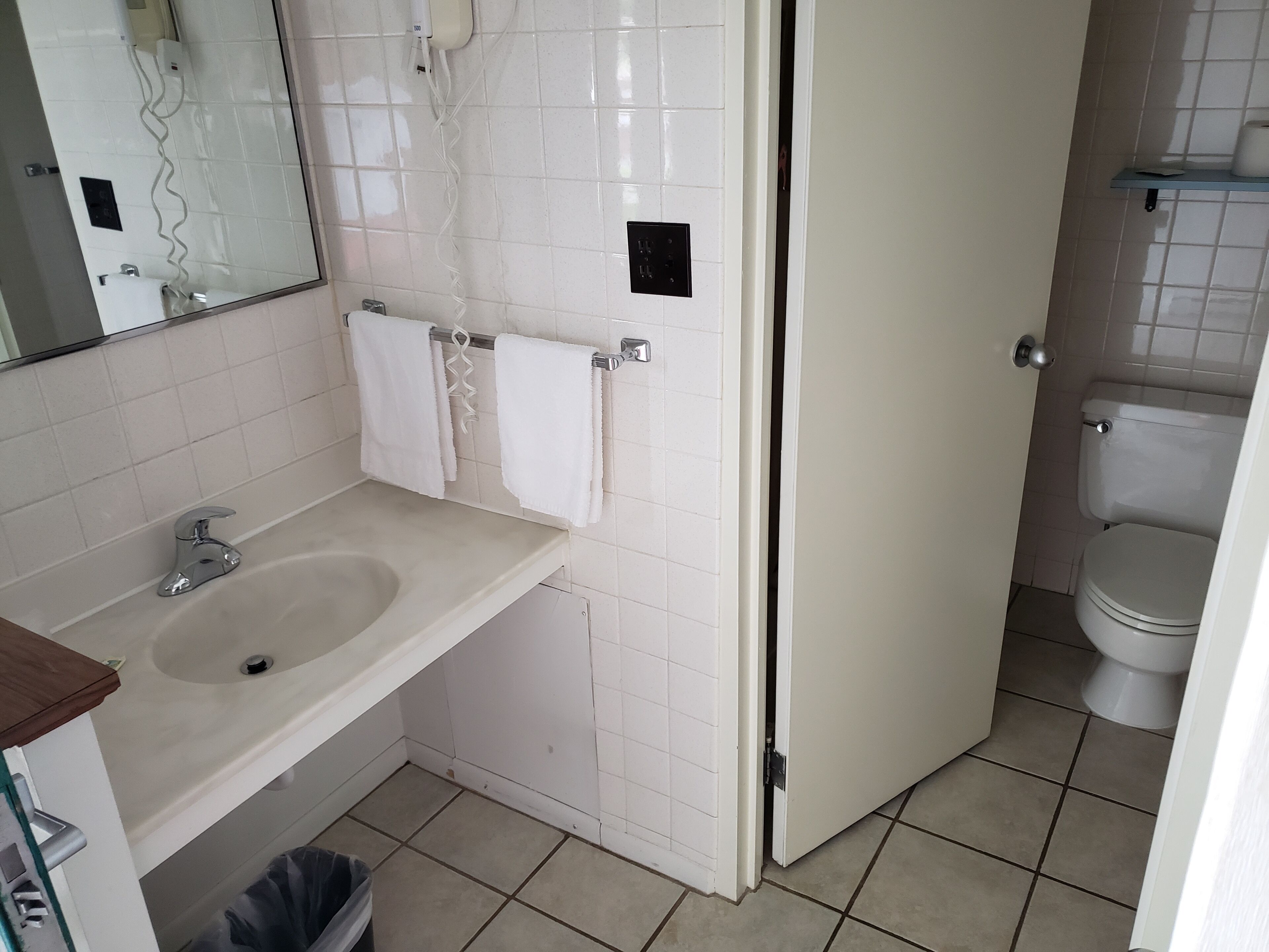 A bathroom with a sink, mirror, and toilet.