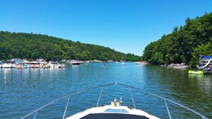 A boat on a lake surrounded by docks with various boats and people. - Huntingdon Motor Inn (Huntingdon)