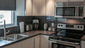 A modern kitchen with stainless steel appliances, including a microwave, toaster, and stove.