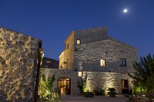 Un edificio de piedra con un patio interior, una luna en el cielo y una ventana pequeña en el piso superior.