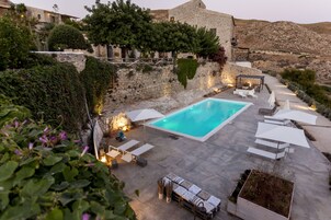 Una piscina al aire libre de temporada, sombrillas