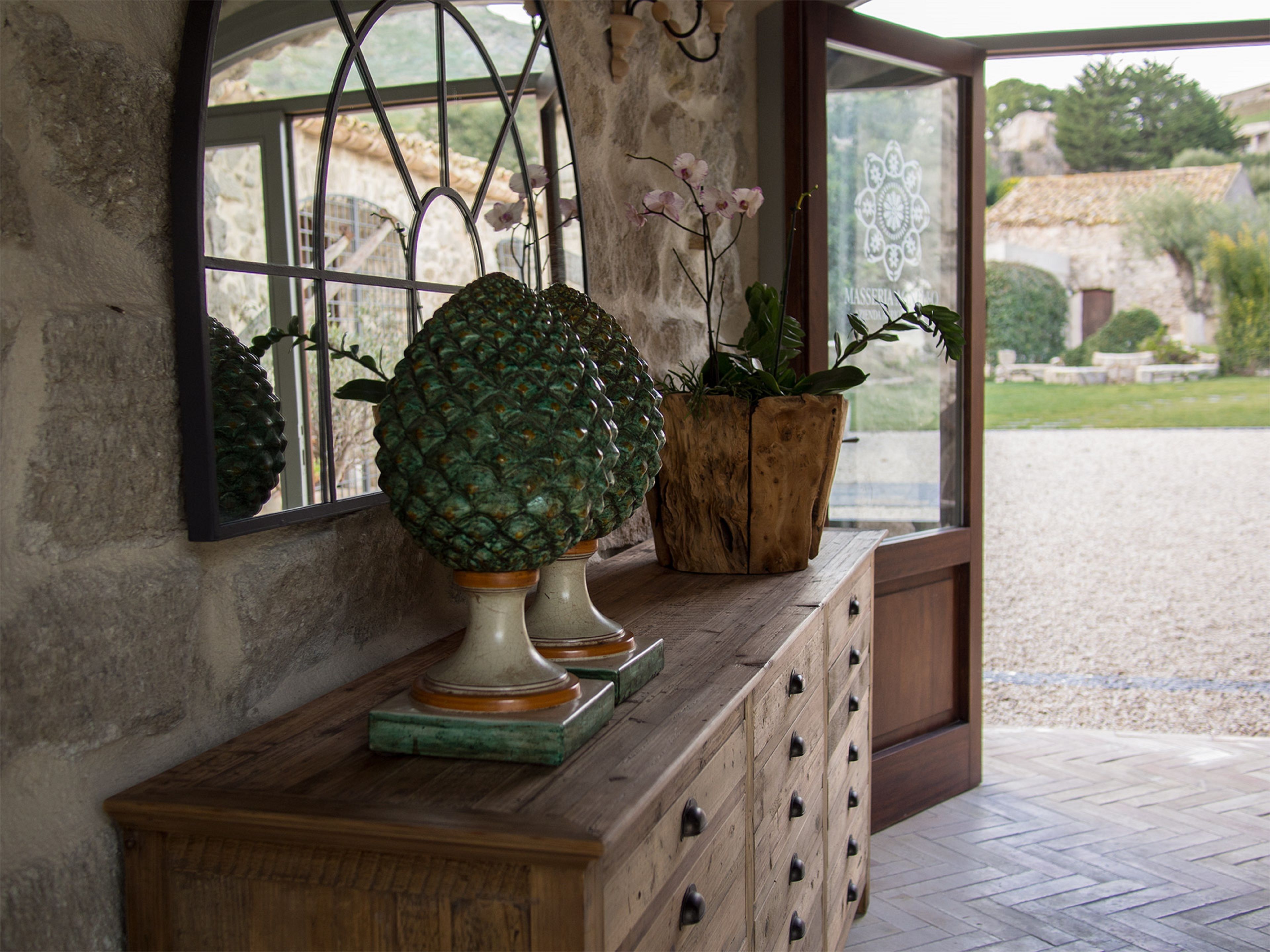 Une console en bois agrémentée de jardinières décoratives et d’un miroir.