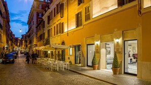 A cobblestone street lined with yellow buildings, outdoor seating, and a hotel entrance. - Hotel della Conciliazione (Rome)