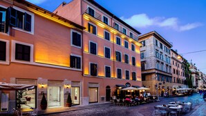 A hotel with outdoor seating, multiple floors, and a cobblestone street. - Hotel della Conciliazione (Rome)