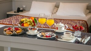 A breakfast table with pastries, fruits, and beverages in a hotel room. - Hotel della Conciliazione (Rome)