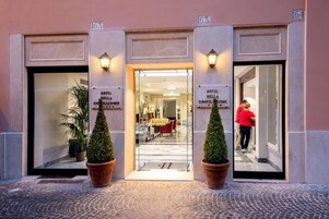 L'ingresso dell'Hotel della Conciliazione, con un interno moderno visibile attraverso le vetrate.