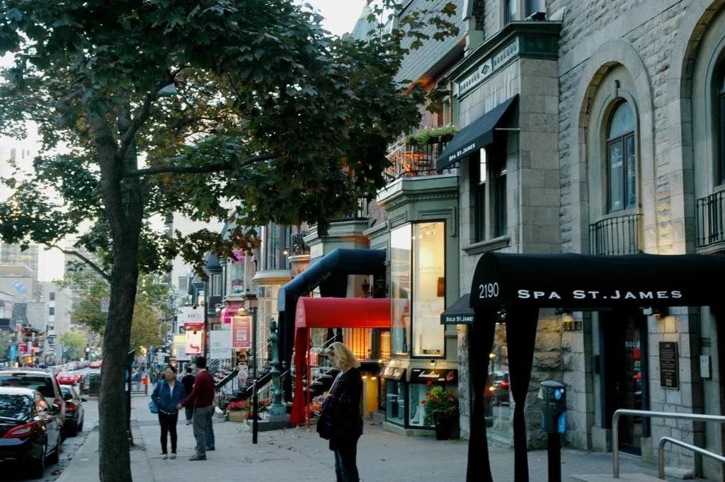 Une vue de rue avec un bâtiment portant l’inscription « Spa St. James » et un trottoir bordé d’arbres.