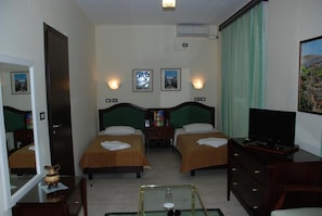 A hotel room with two beds, a television, a desk, and a mirror. - Cajupi (Gjirokastër)