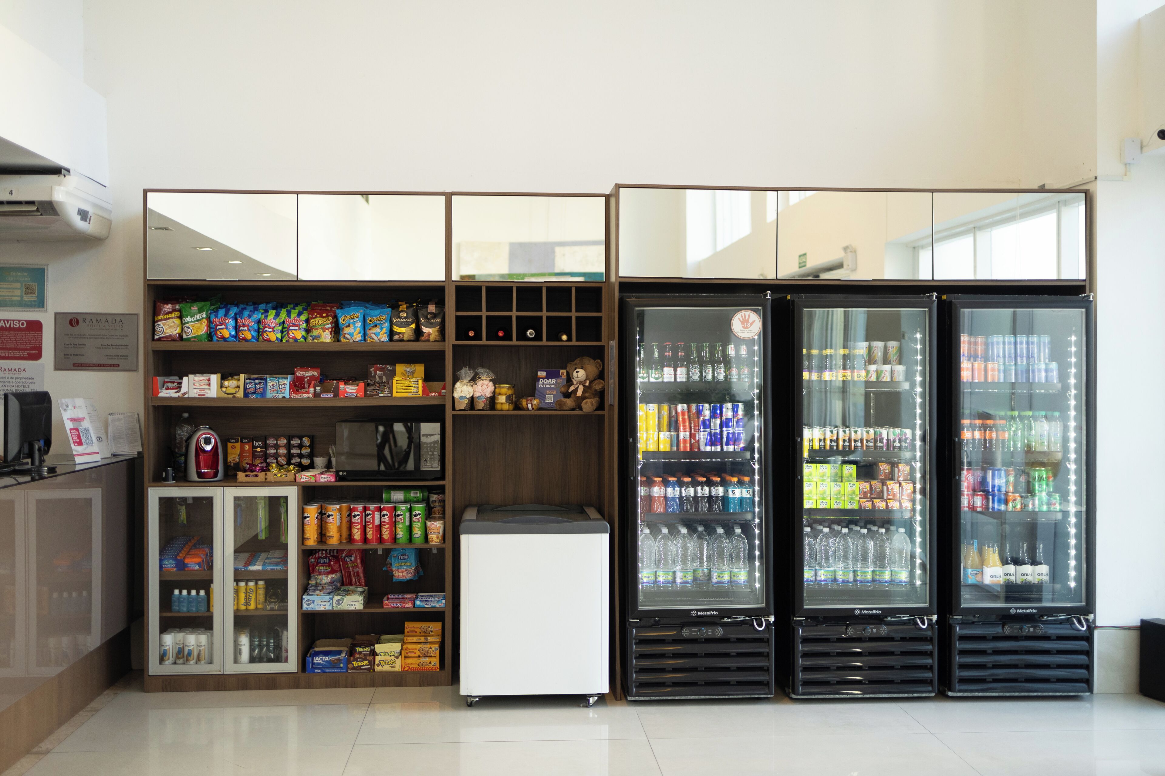 Zona de venta con opciones de bocadillos y bebidas, que incluye un refrigerador y un microondas.