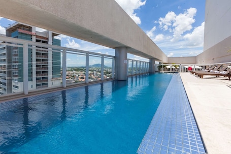 Una piscina al aire libre, sillones reclinables de piscina