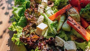 A wooden table with a salad.