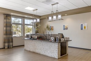 A modern kitchen with a brick island, pendant lights, and a view of the outdoors. - Best Western Plus Havre Inn & Suites (Havre)
