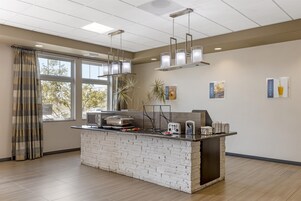 Cozinha moderna com ilha de tijolos, luminárias pendentes e vista para o exterior.