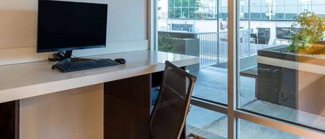 Un espace de bureau moderne comprenant un bureau, un ordinateur et une chaise.