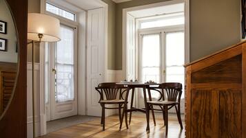 Un comedor con una mesa, sillas, una lámpara y una escalera de madera.