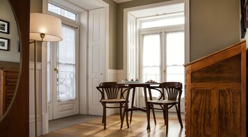 A dining area with a table and chairs, a lamp, and a wooden staircase.