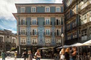 Un bâtiment historique orné de carreaux décoratifs bleus et blancs, doté de nombreux balcons et d’espaces de détente en plein air.