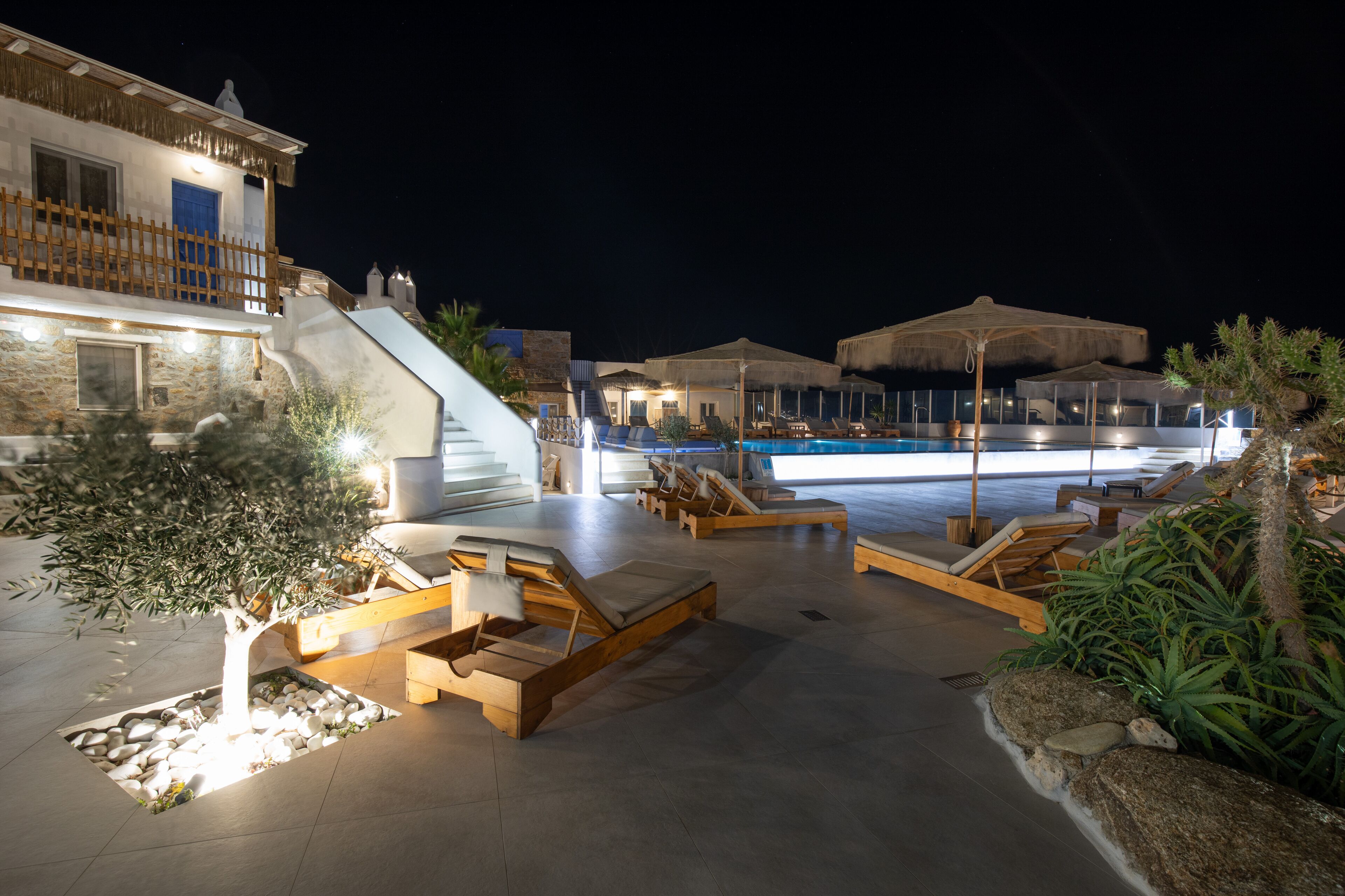 A poolside area with lounge chairs and a pool.