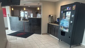 A reception area with a black counter, a water dispenser, and a vending machine. - Red Roof Inn Anderson, IN (Anderson)