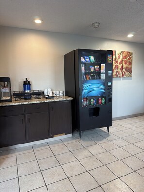 A kitchenette with a coffee maker, a water dispenser, and a vending machine. - Red Roof Inn Anderson, IN (Anderson)