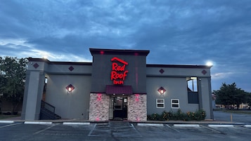 Un Red Roof Inn con fachada de piedra y cielo despejado.