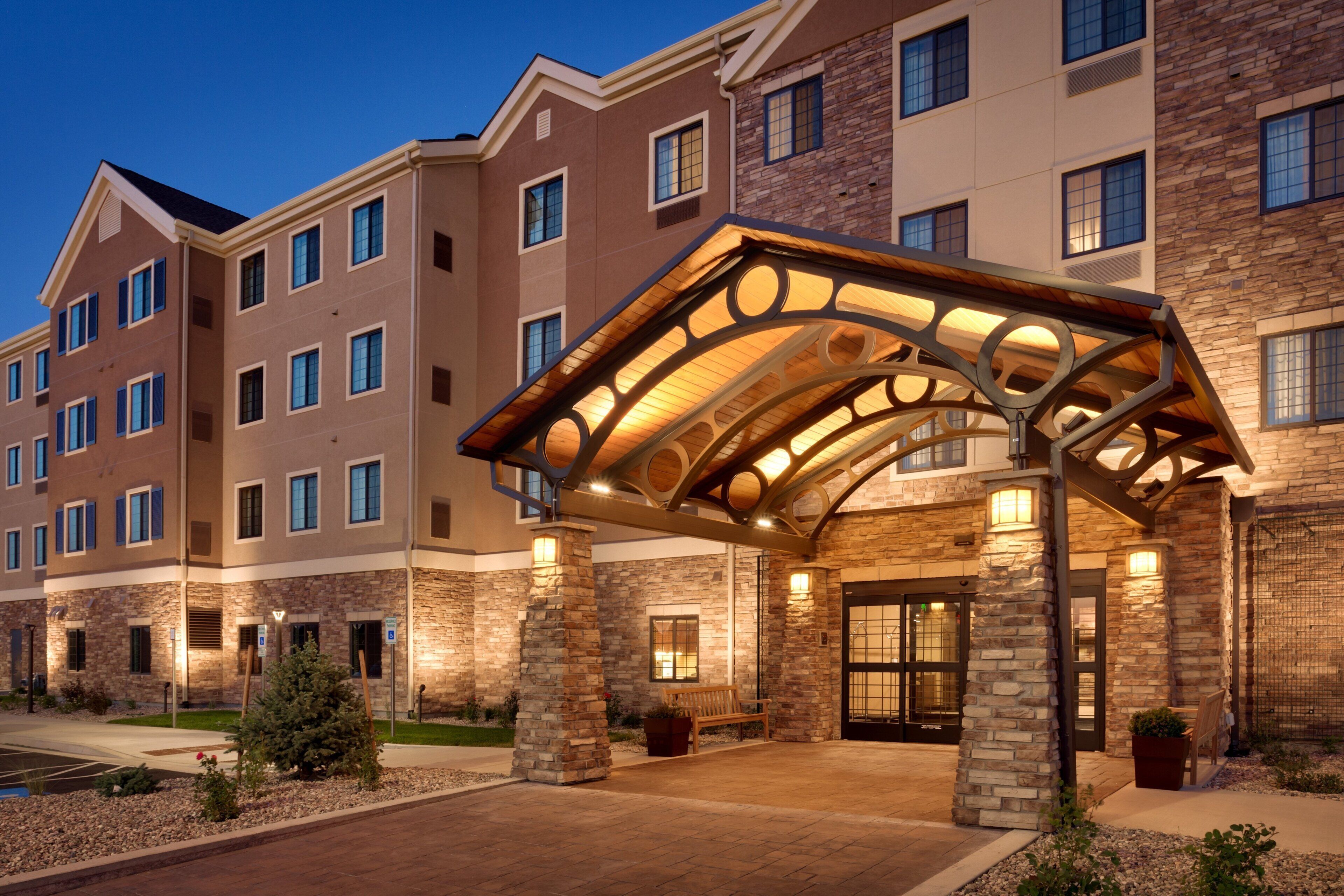 A multi-story hotel with a covered entrance, stone facade, and multiple windows.