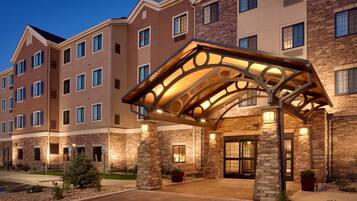 A multi-story hotel with a covered entrance, stone facade, and multiple windows.