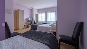 A hotel room with two beds, a desk with a computer, a chair, and a wardrobe. - Hotel du Lauragais (Villefranche-de-Lauragais)