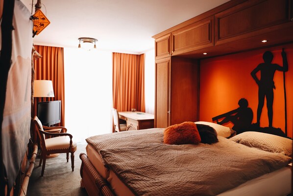 A hotel room with a bed, a desk, a chair, and a television. - Hotel Arte (St. Moritz)