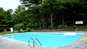 Une piscine avec un panneau indiquant que l’eau est peu profonde et qu’il est interdit de plonger.