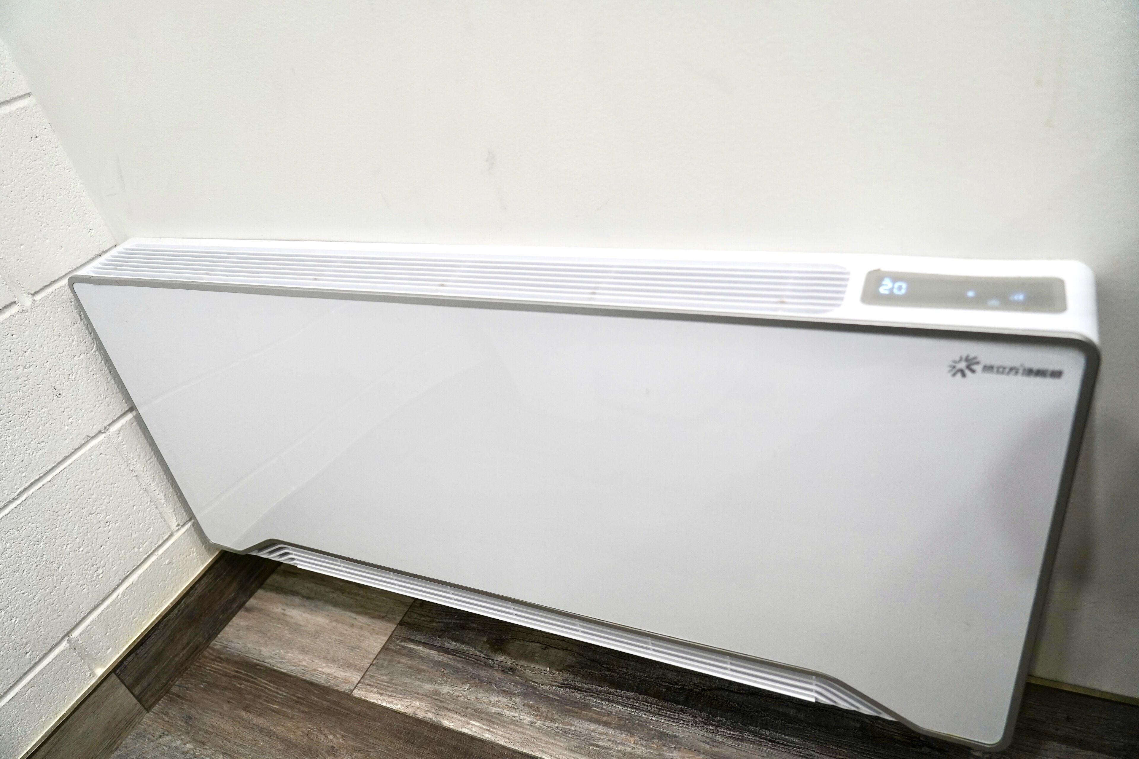 A white wall-mounted radiator with a digital display.