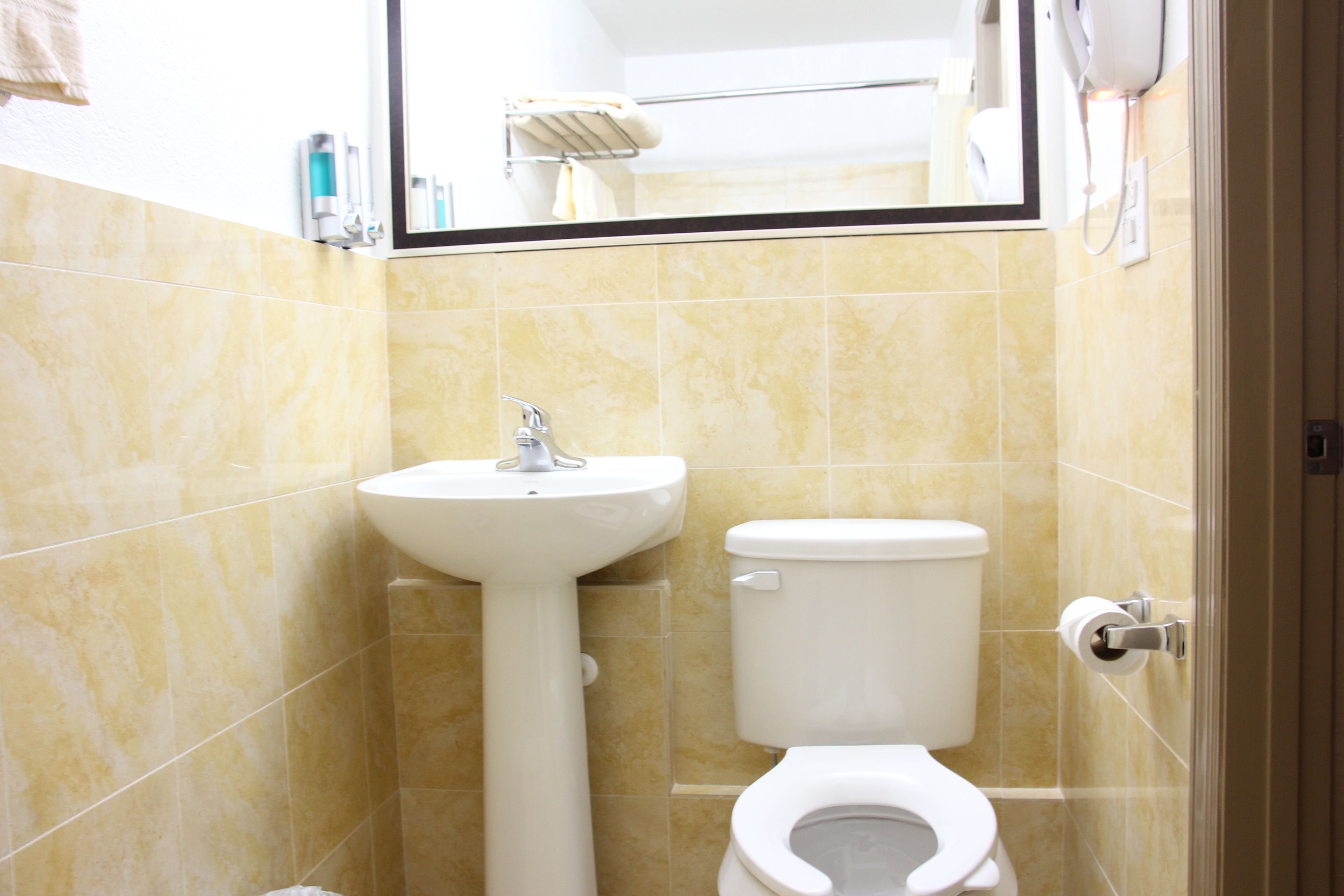 Une salle de bain avec un lavabo, des toilettes et un miroir.