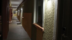 A corridor with a textured wall and a door on the right.