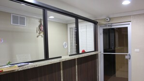 A reception area with a counter, a door with a glass panel, and a wall-mounted security camera.